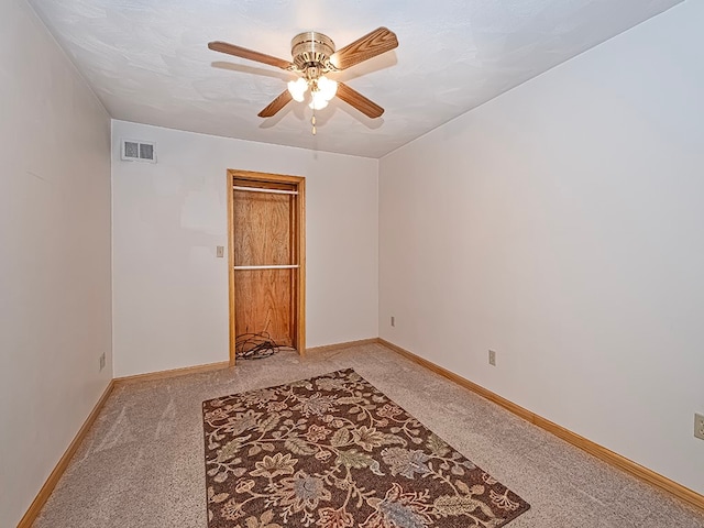 carpeted empty room featuring ceiling fan