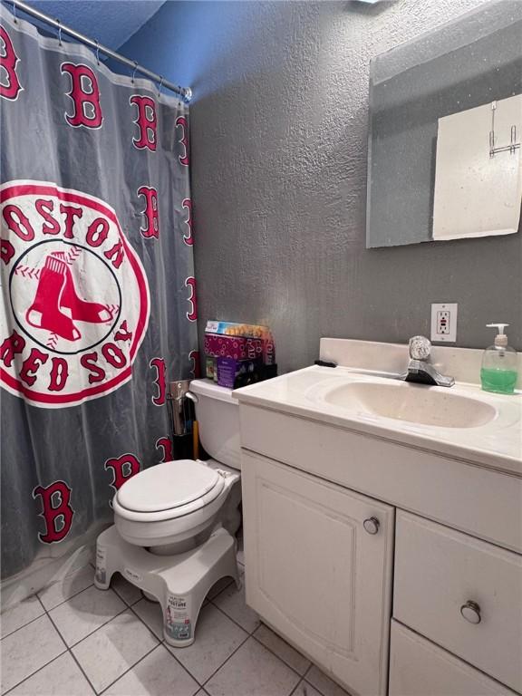 bathroom featuring tile patterned floors, vanity, and toilet