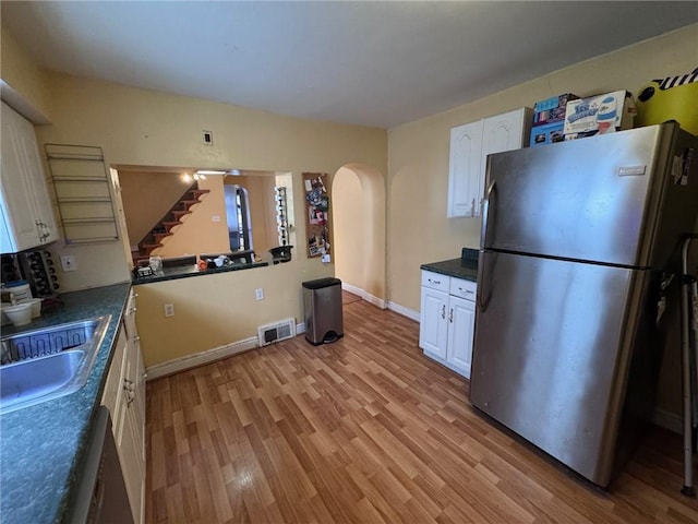 kitchen with light hardwood / wood-style floors, white cabinetry, sink, and appliances with stainless steel finishes