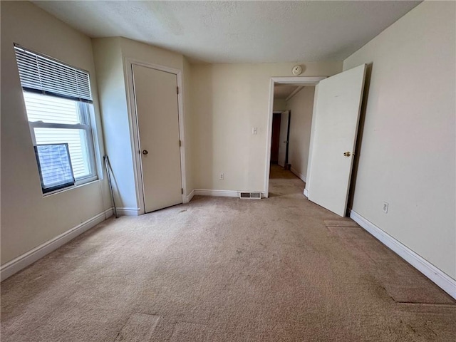 unfurnished room featuring light colored carpet