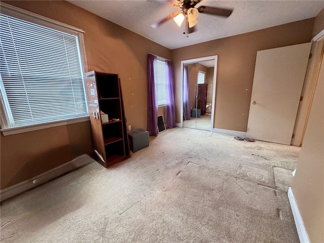 interior space with ceiling fan and a textured ceiling