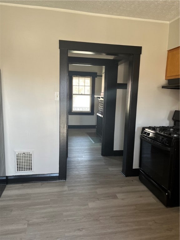 kitchen featuring wood-type flooring, black range with gas cooktop, and a textured ceiling