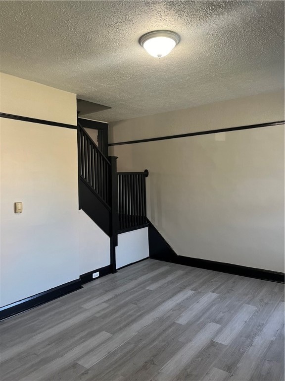 staircase featuring wood-type flooring and a textured ceiling