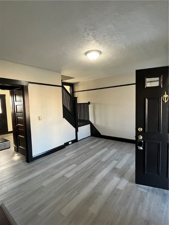 foyer featuring light hardwood / wood-style floors and a textured ceiling