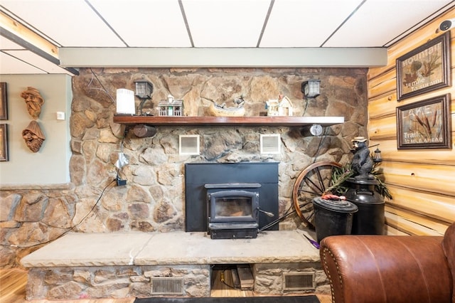 interior details featuring a wood stove, wood walls, and wood-type flooring