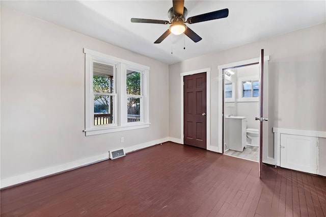 unfurnished bedroom with ceiling fan, connected bathroom, and dark hardwood / wood-style flooring