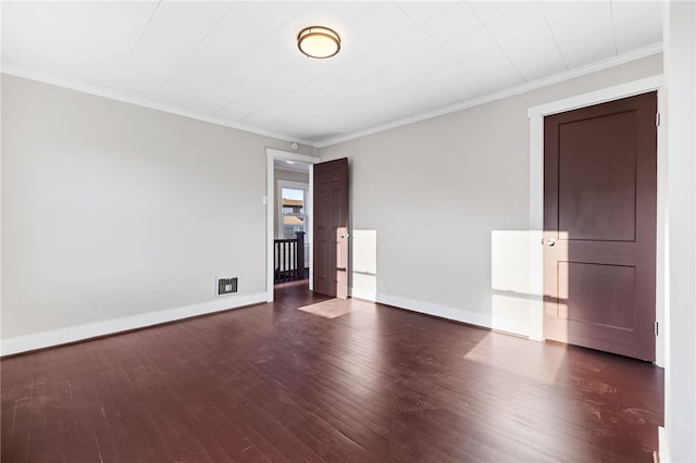 empty room featuring ornamental molding and dark hardwood / wood-style floors