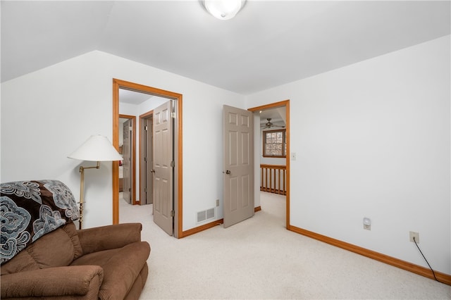 sitting room with light colored carpet, vaulted ceiling, and ceiling fan