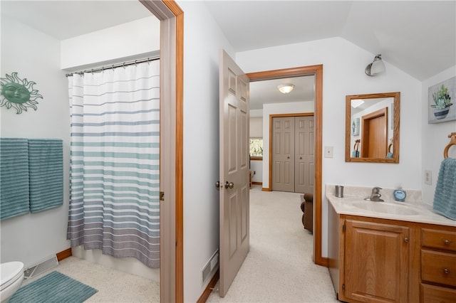 bathroom featuring vanity, a shower with shower curtain, vaulted ceiling, and toilet