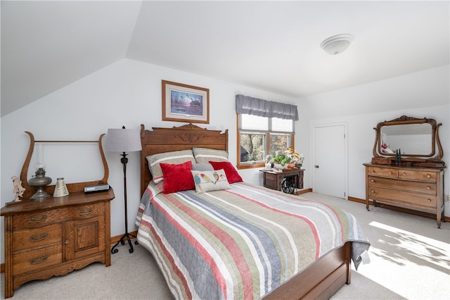 bedroom with light colored carpet and vaulted ceiling