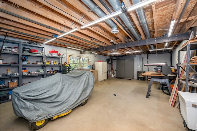 basement with a workshop area and white refrigerator