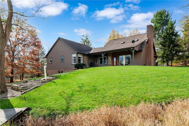 rear view of house featuring a lawn