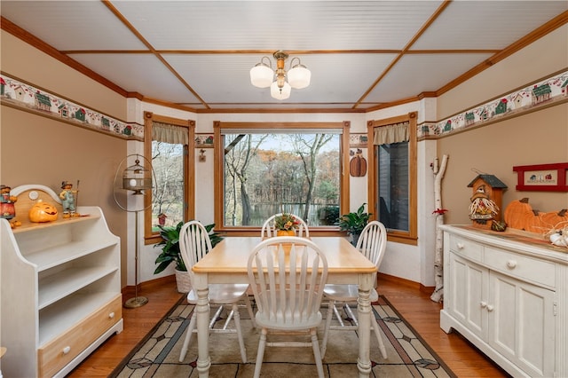 dining area featuring an inviting chandelier, light hardwood / wood-style flooring, and crown molding