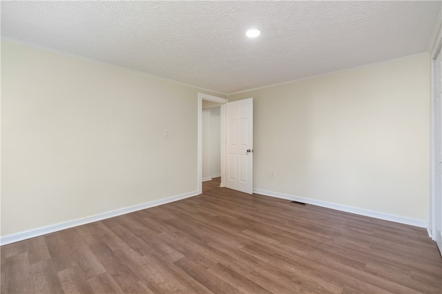 spare room with a textured ceiling and hardwood / wood-style floors