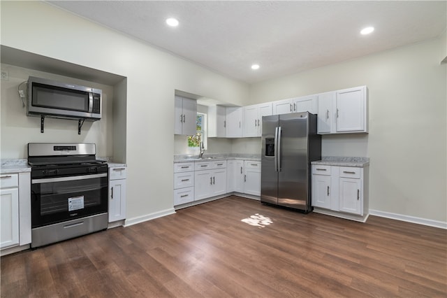 kitchen with white cabinetry, appliances with stainless steel finishes, dark hardwood / wood-style flooring, and sink