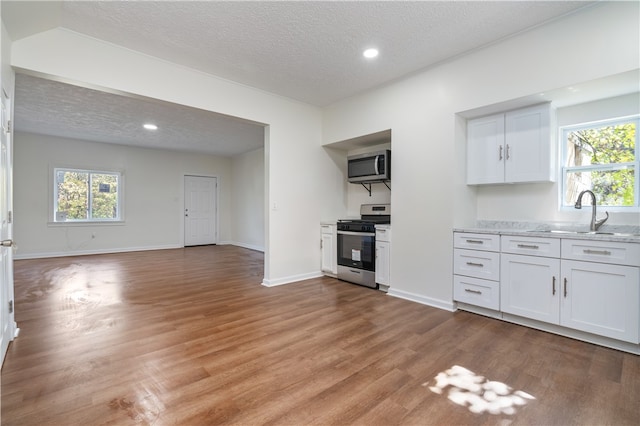 kitchen with sink, appliances with stainless steel finishes, a textured ceiling, and white cabinetry