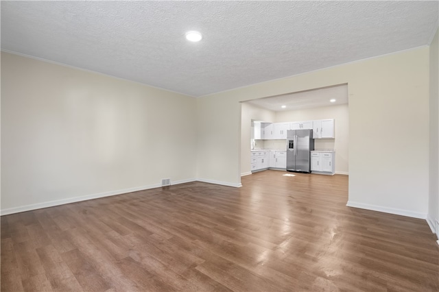 unfurnished living room featuring a textured ceiling and hardwood / wood-style flooring