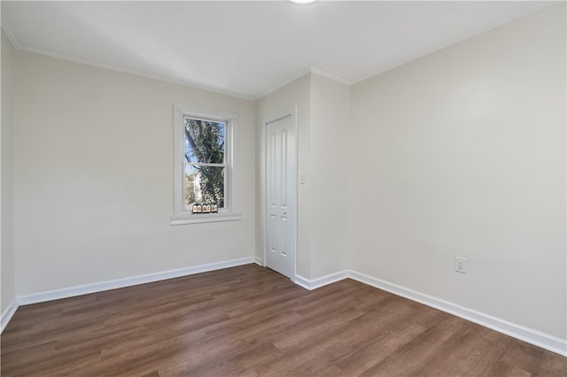 spare room featuring ornamental molding and dark hardwood / wood-style flooring