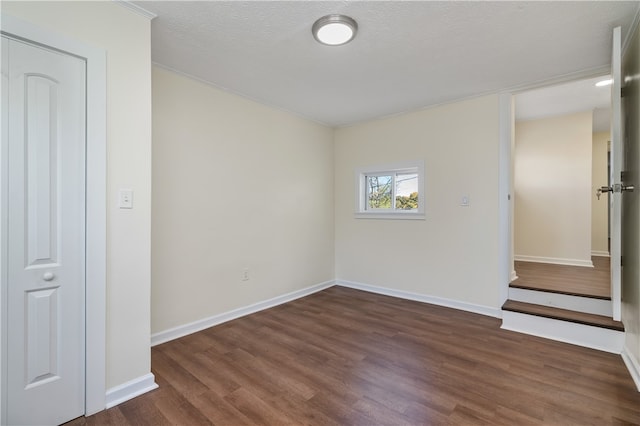 unfurnished room with dark hardwood / wood-style floors and a textured ceiling