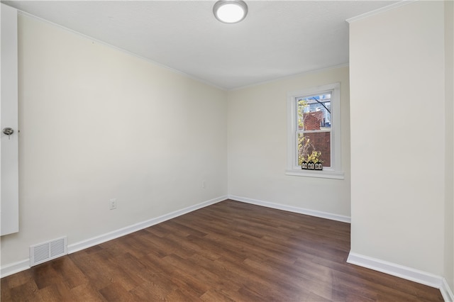 empty room with ornamental molding and dark hardwood / wood-style flooring