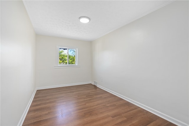 spare room featuring a textured ceiling and dark hardwood / wood-style flooring