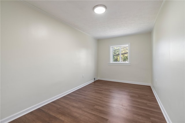 unfurnished room with crown molding, a textured ceiling, and dark hardwood / wood-style flooring