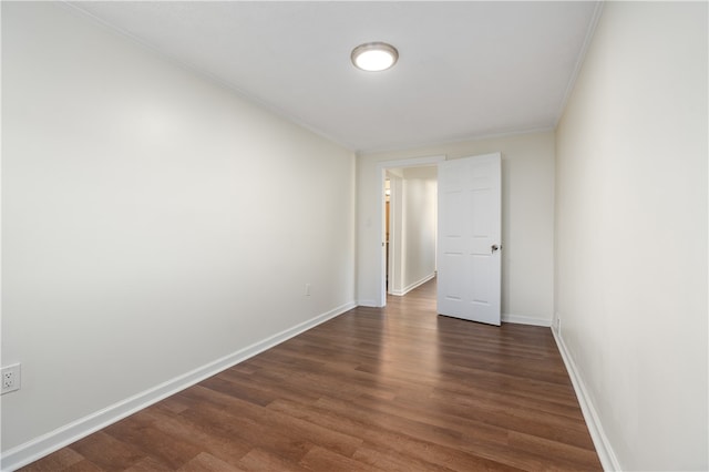 empty room with crown molding and dark hardwood / wood-style floors