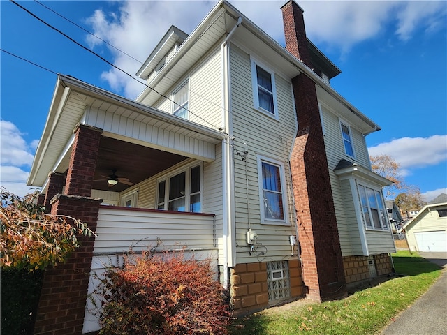 view of side of home with a garage and ceiling fan