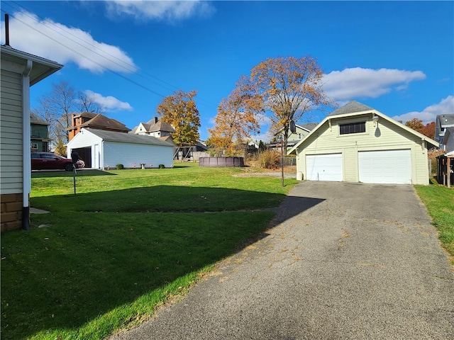 view of yard featuring a garage and an outbuilding