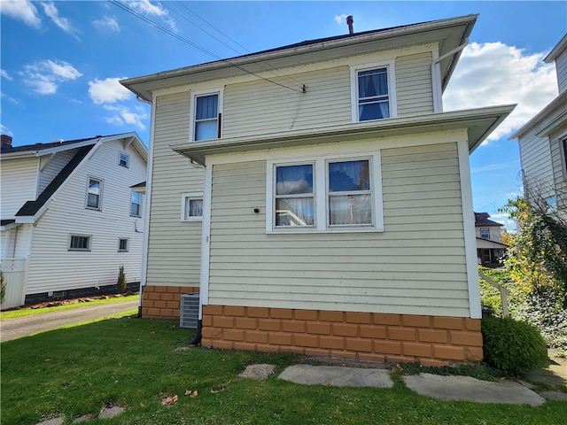 view of side of home featuring a yard and cooling unit