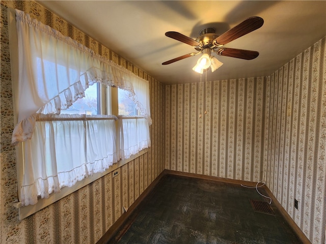 empty room with ceiling fan and dark parquet floors