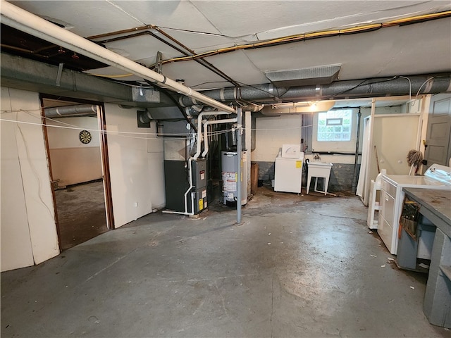 basement with heating unit, washing machine and dryer, and gas water heater