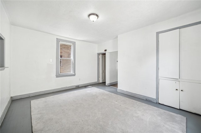 unfurnished bedroom featuring a textured ceiling and a closet