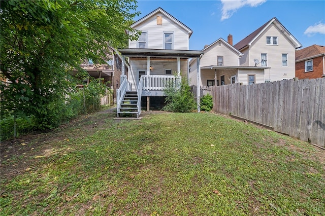 rear view of house with a deck and a lawn