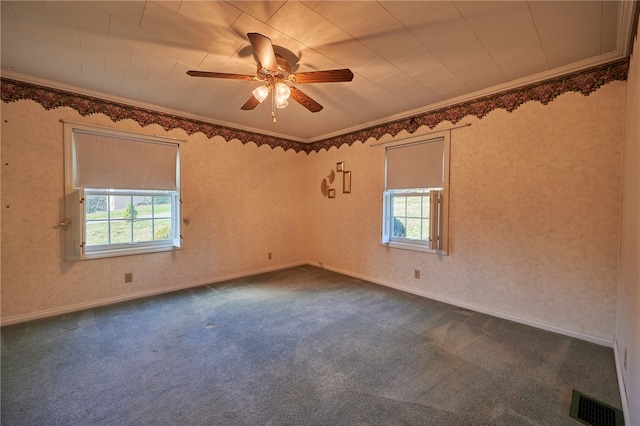 unfurnished room featuring crown molding, dark carpet, and ceiling fan