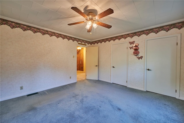 unfurnished bedroom featuring ornamental molding, carpet, and ceiling fan