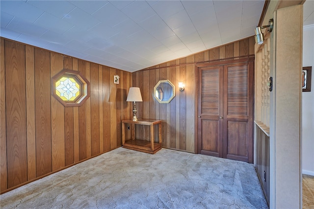 carpeted foyer with wood walls