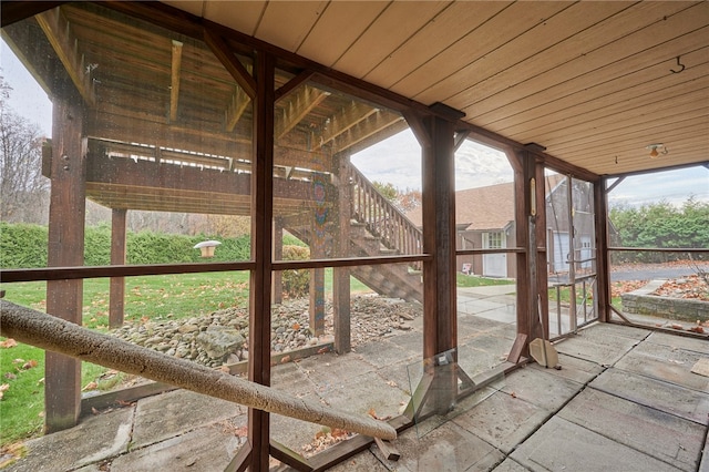 unfurnished sunroom featuring a wealth of natural light and wooden ceiling