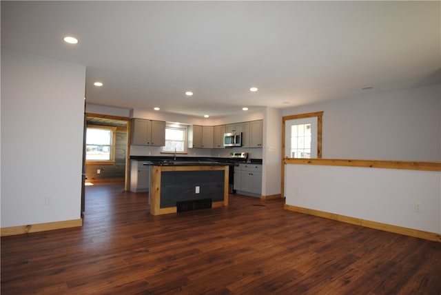 kitchen with gray cabinets, a center island, dark wood-type flooring, and sink