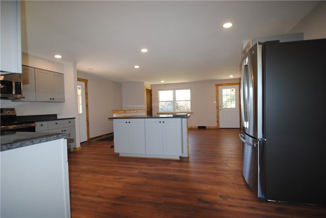 kitchen featuring stainless steel appliances, dark hardwood / wood-style flooring, and white cabinets