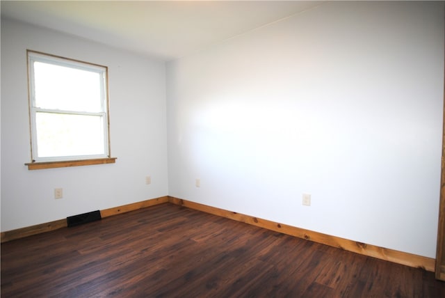 empty room with dark hardwood / wood-style flooring