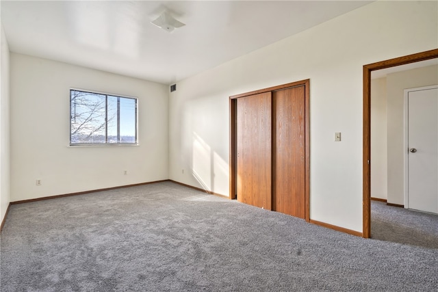 unfurnished bedroom featuring carpet flooring and a closet