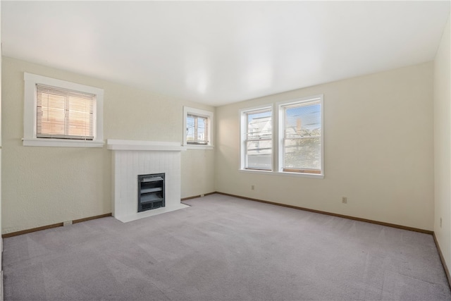 unfurnished living room with light carpet and a brick fireplace