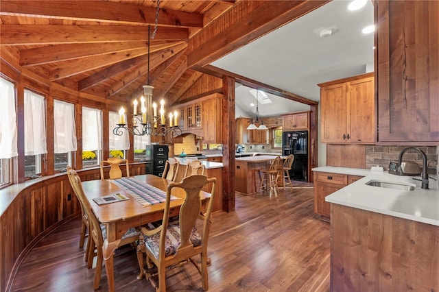 dining room featuring an inviting chandelier, wooden ceiling, dark wood-type flooring, vaulted ceiling with skylight, and sink