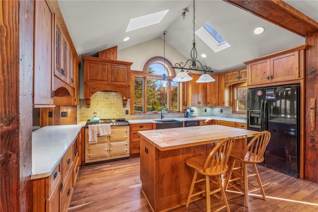 kitchen featuring wooden counters, a center island, light hardwood / wood-style flooring, and black fridge