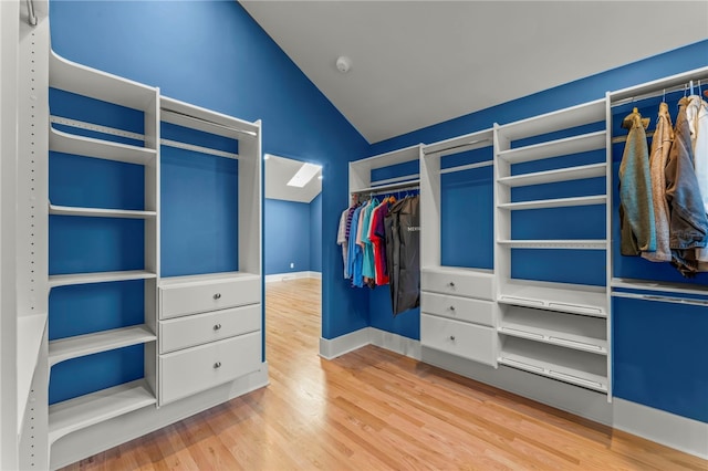 walk in closet with lofted ceiling with skylight and wood-type flooring