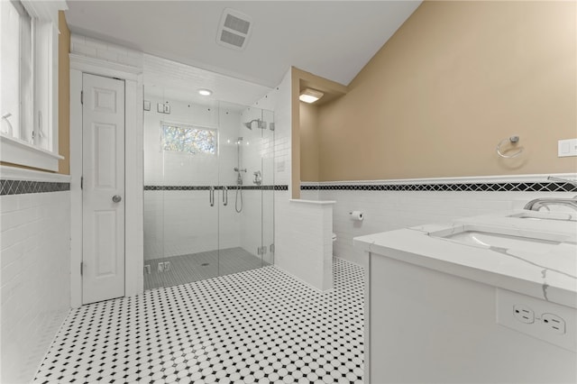 bathroom with vanity, tile walls, lofted ceiling, and an enclosed shower