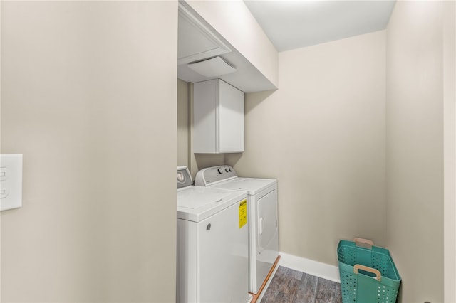 laundry room featuring dark wood-type flooring, cabinets, and separate washer and dryer