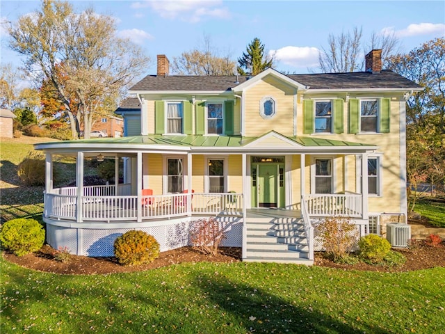 view of front of property featuring a porch, a front lawn, and central AC unit