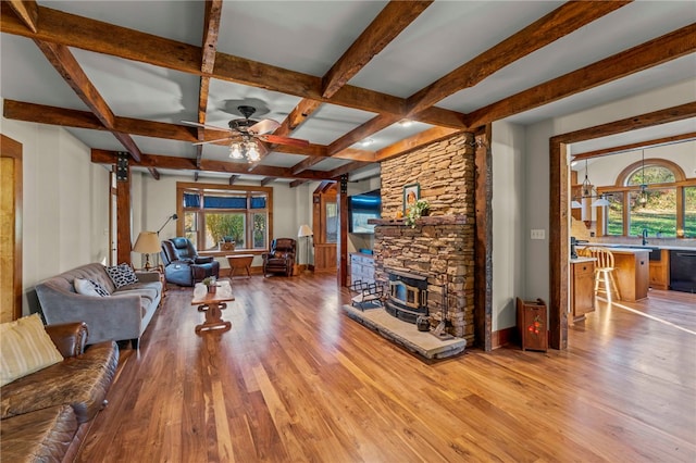 living room with light hardwood / wood-style floors, beam ceiling, plenty of natural light, and ceiling fan